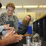 Rhodenizer helps students perform a lab. 