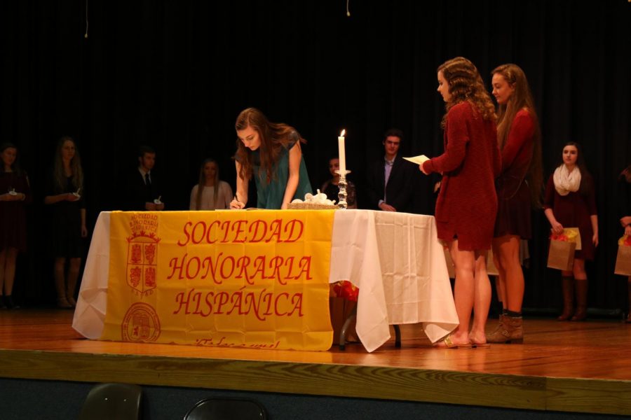 Senior Ashley Peckham signing the member book at the Spanish Honor Society Induction. 