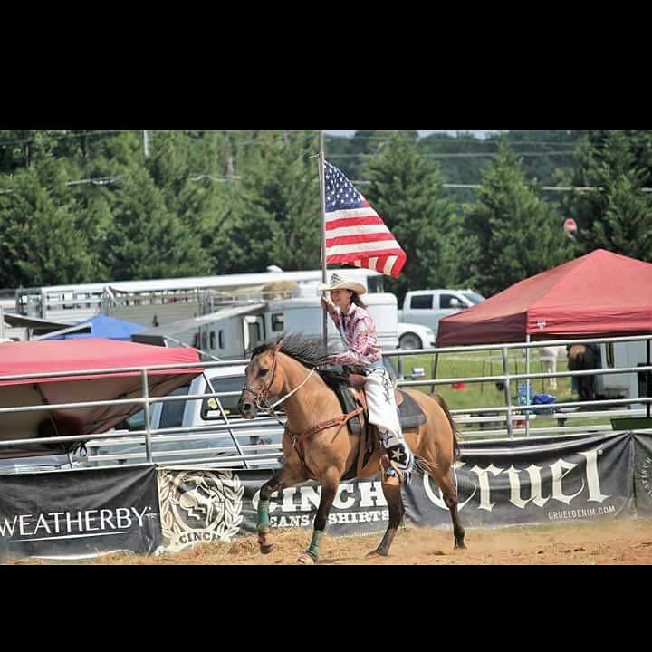 Makayla Back competes in a rodeo while holding a flag. 