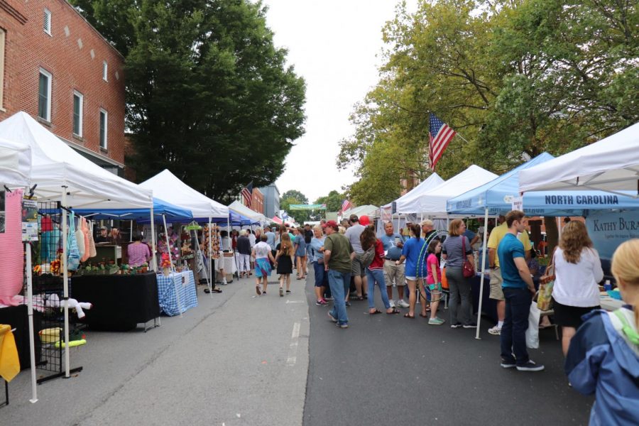 Community members walk downtown to view all the booths. 