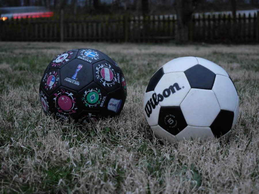A couple of soccer balls on the ground.