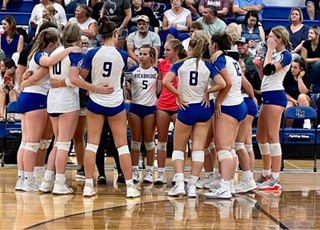 Girls Volleyball huddles together to discuss plans for the rest of the game.