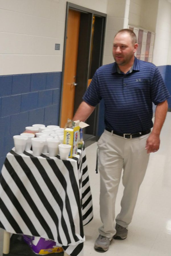 Mr. Andy Coffey moves the cart down the hallway.
