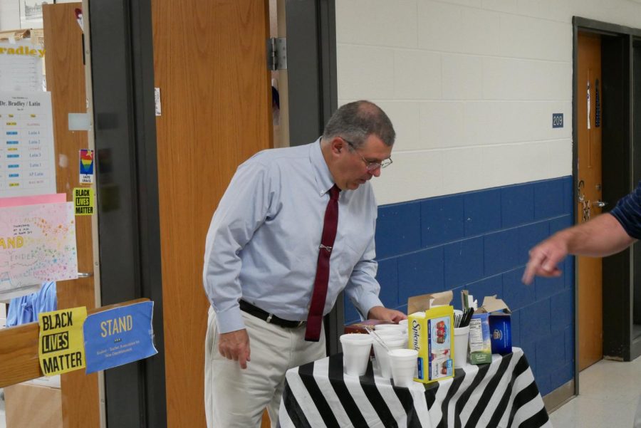Dr. Pat Bradley selects coffee from the cart. 