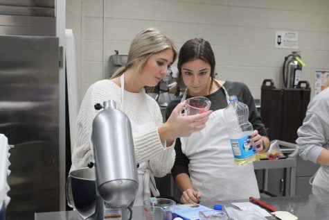 Jaden McCoy and Sydney Boucher measure out vegetable oil to begin making the cupcakes. Photo taken by Cameron Terry.

