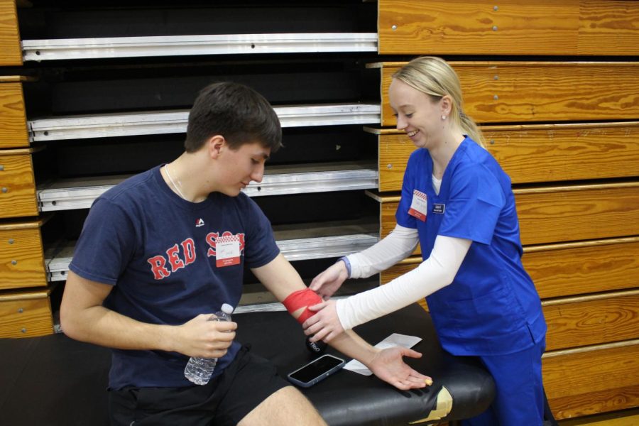 Junior Addie Wright bandages a donor after their donation. Photo by Maxwell Pearson