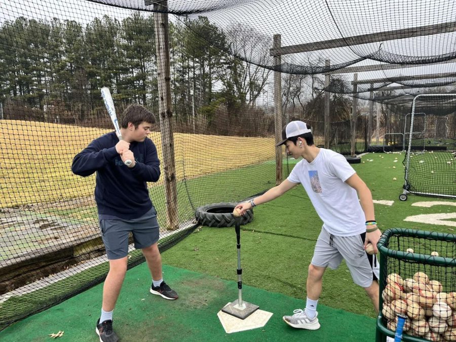 Junior Zac Majors and Sophomore Ayron Wu practice at the batting cage.