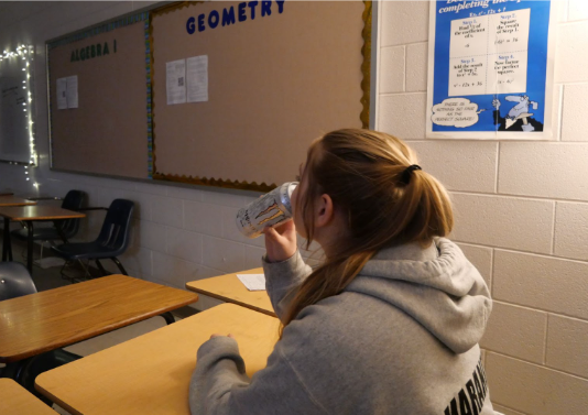 A student drinking a sugar-free monster during class.