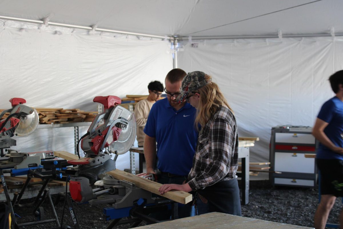 Colter Bennett, CTE Teacher, working with students in a temporary outdoor tent. 
Photo taken by Addie Flint.
