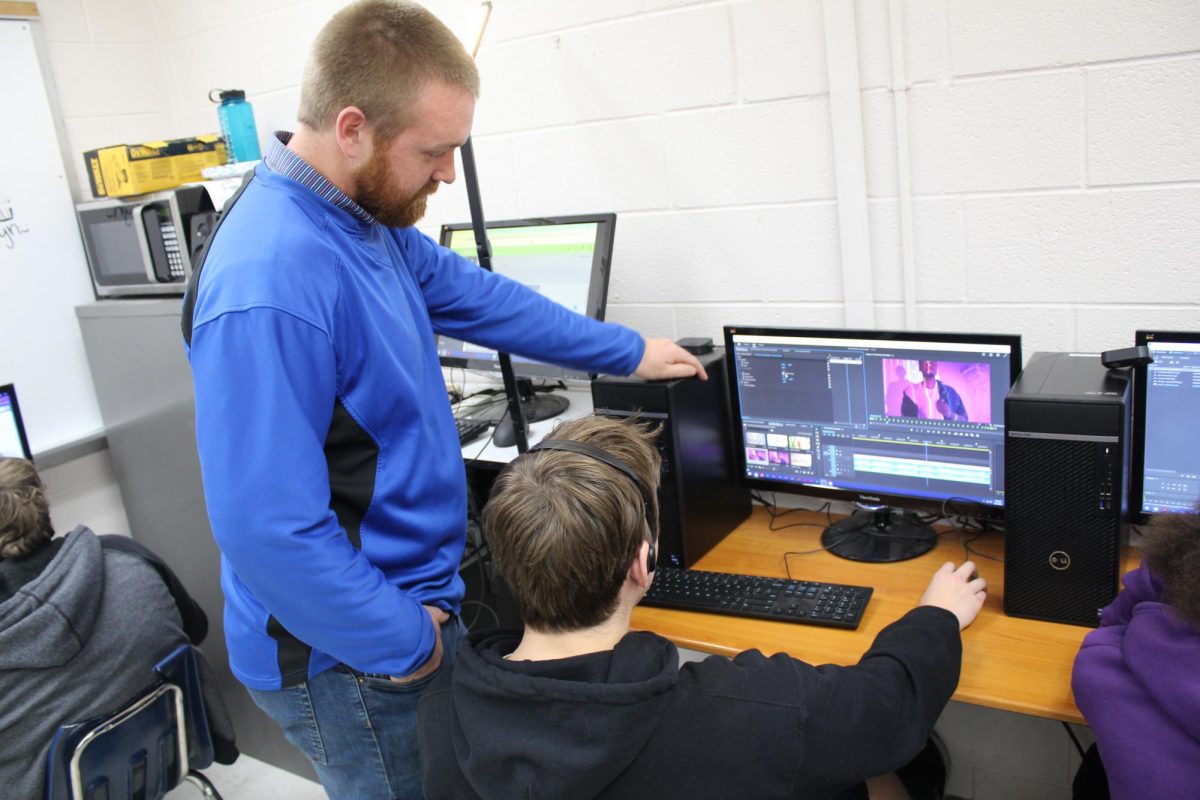 Colter Bennett works with a student on Adobe Premiere. Photo by Eliot McDonald. 