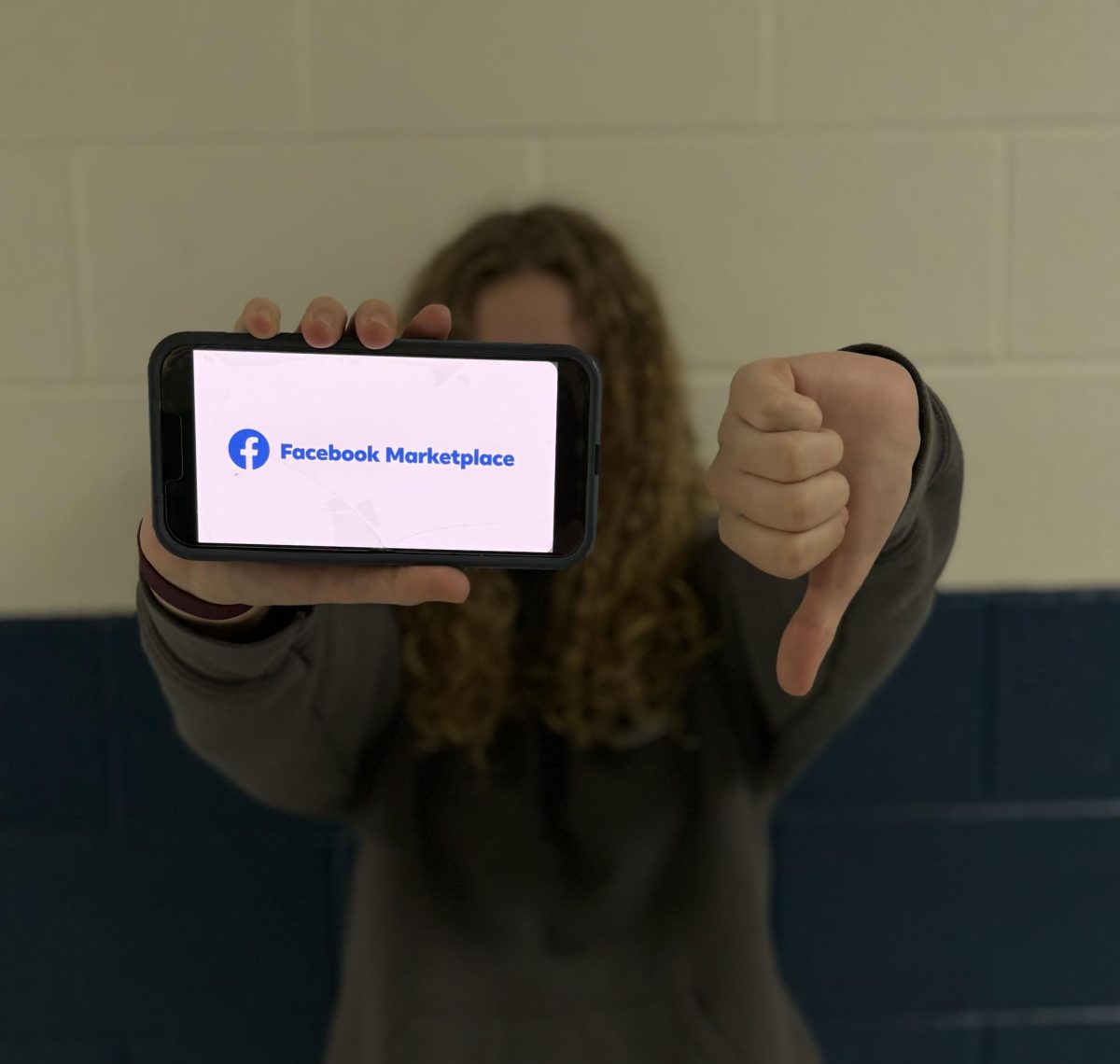 Student+holds+a+thumbs+down+at+the+Facebook+Marketplace+App.