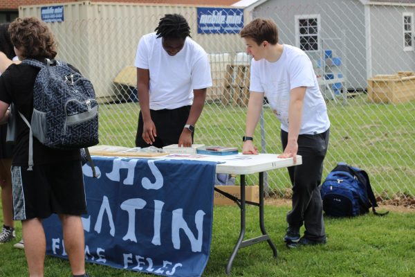 Seniors Kalu Abah and Charles Lowney at the latin club table for Earth Day.