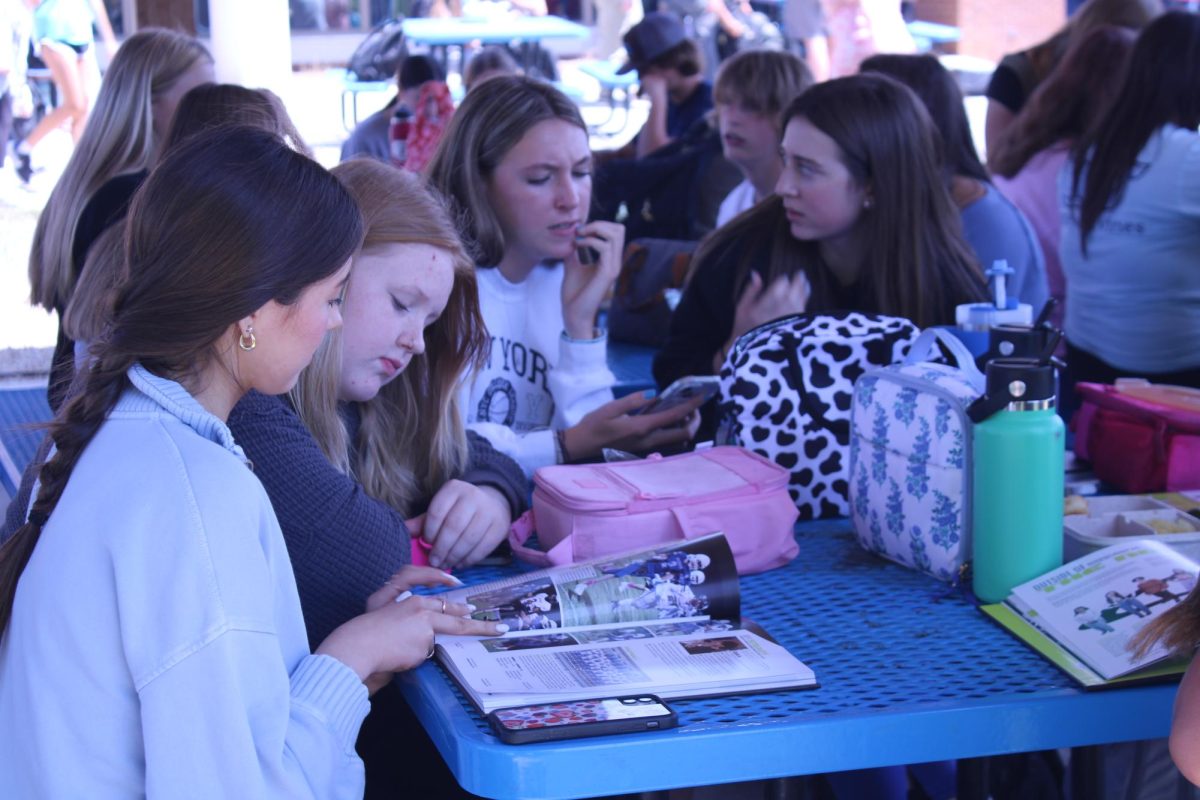 Students look over yearbook.