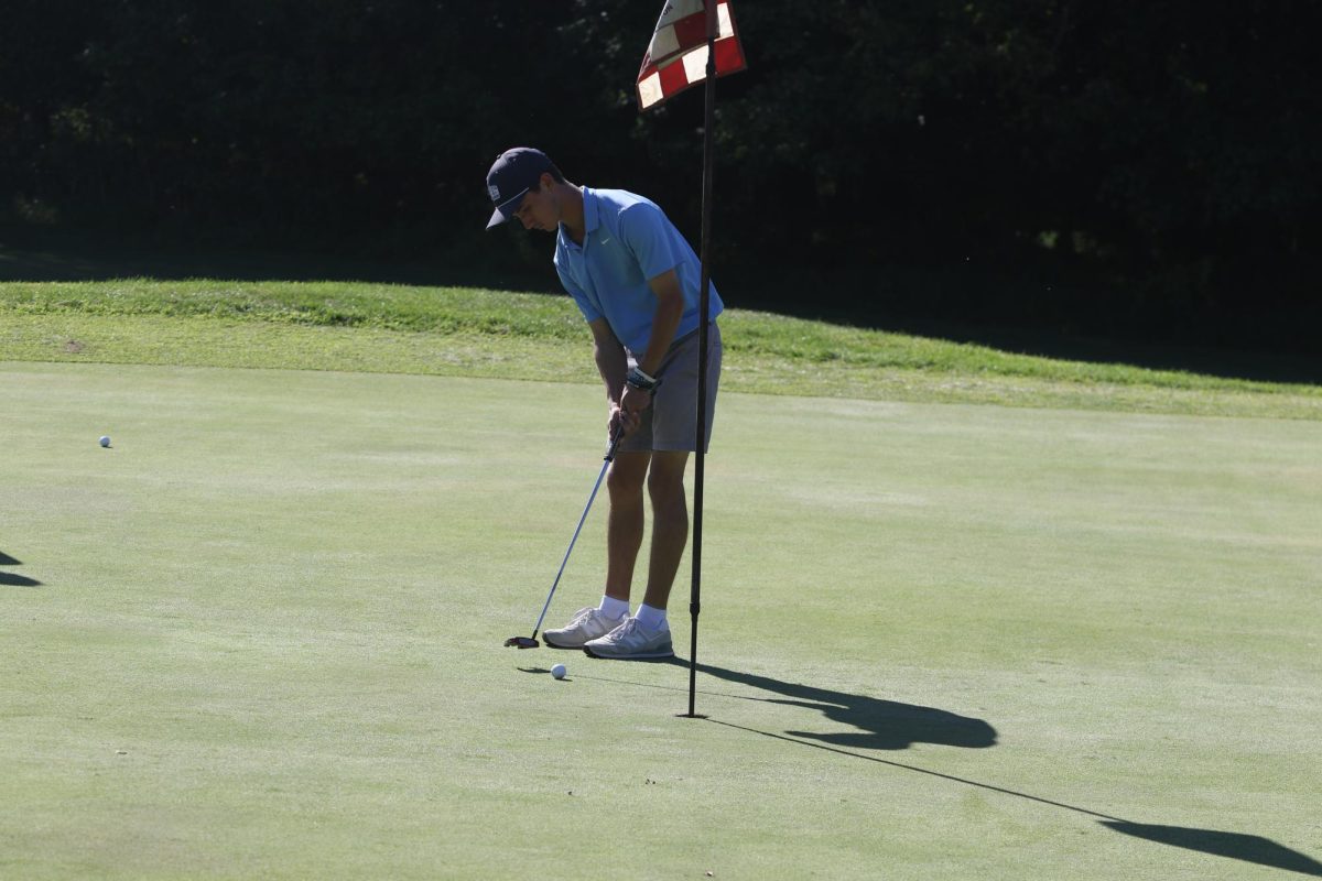 Senior Andrew McCoy sinks a putt