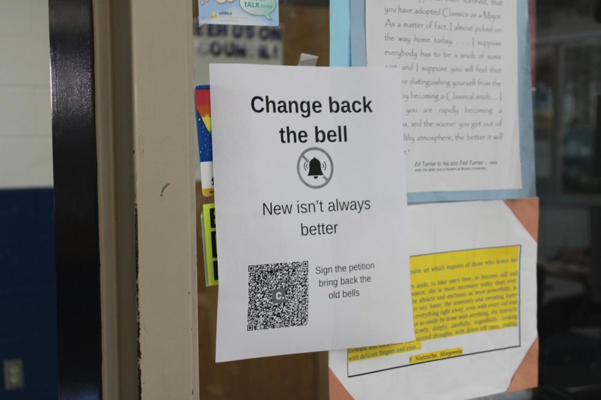 Student hangs posters to influence students to help change the bells.