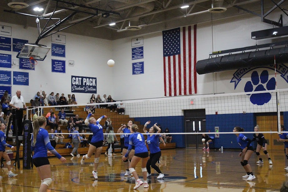 Casadee Mauck hits the ball over the net as teammates cover for a potential block. 