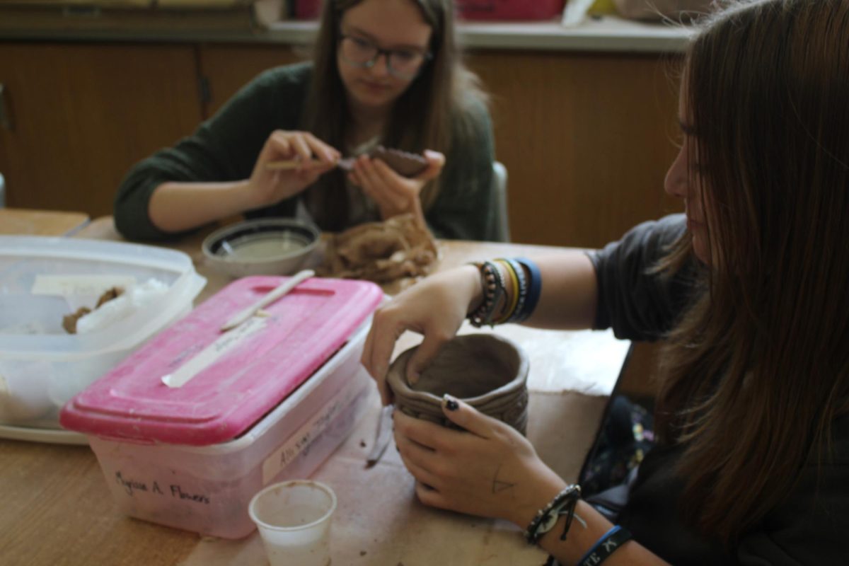 Ceramic students work on their vases. 