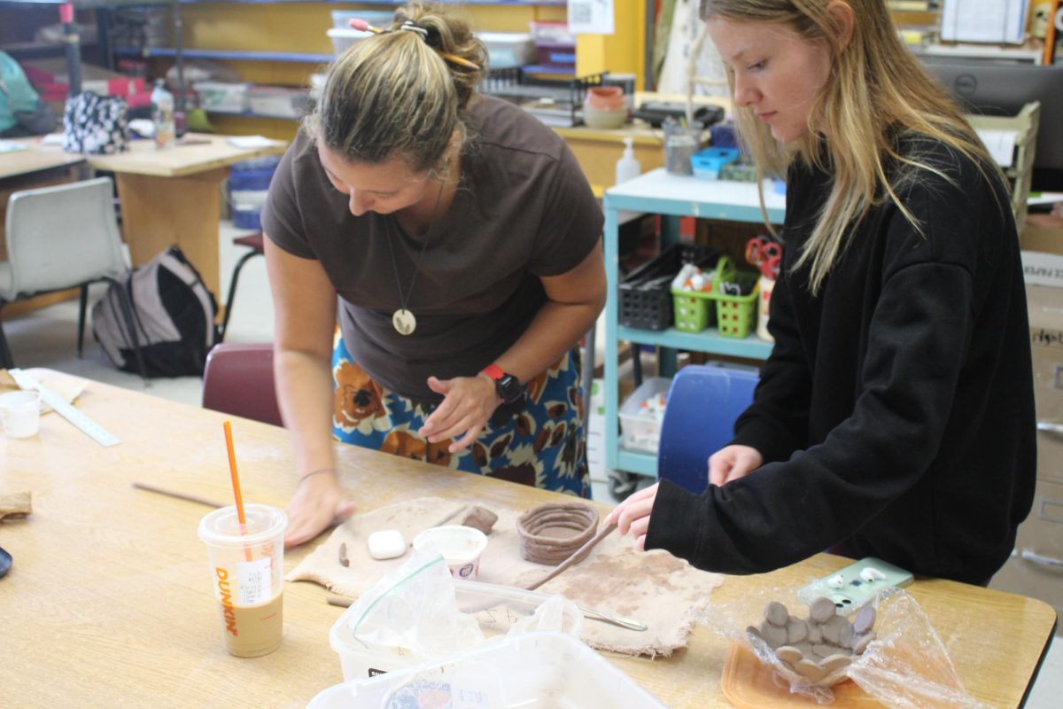 Ms. McKenzie assist a student. 