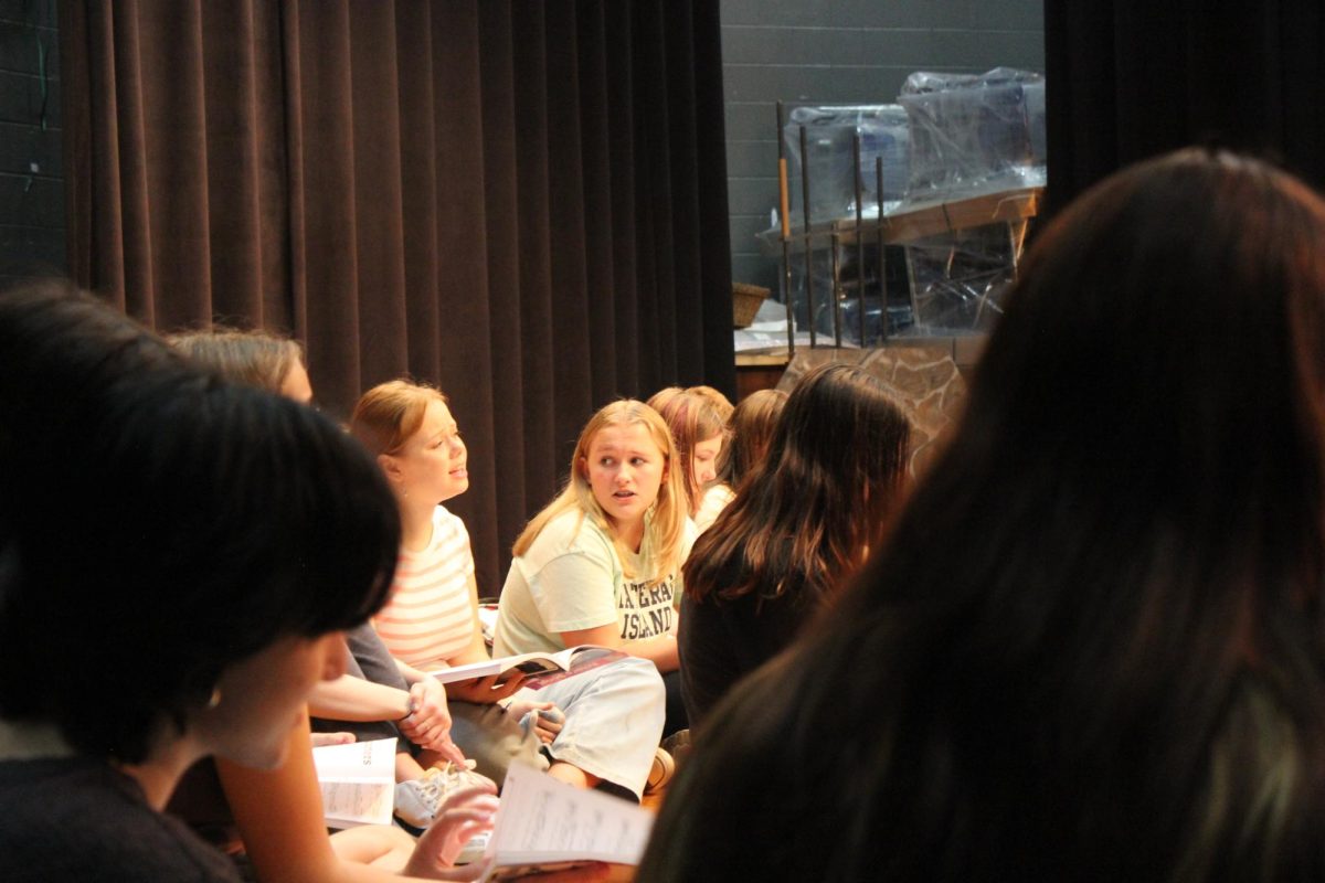 (left to right) Lilly Jackson, Abigail Woodford, and others start vocal warm-ups.