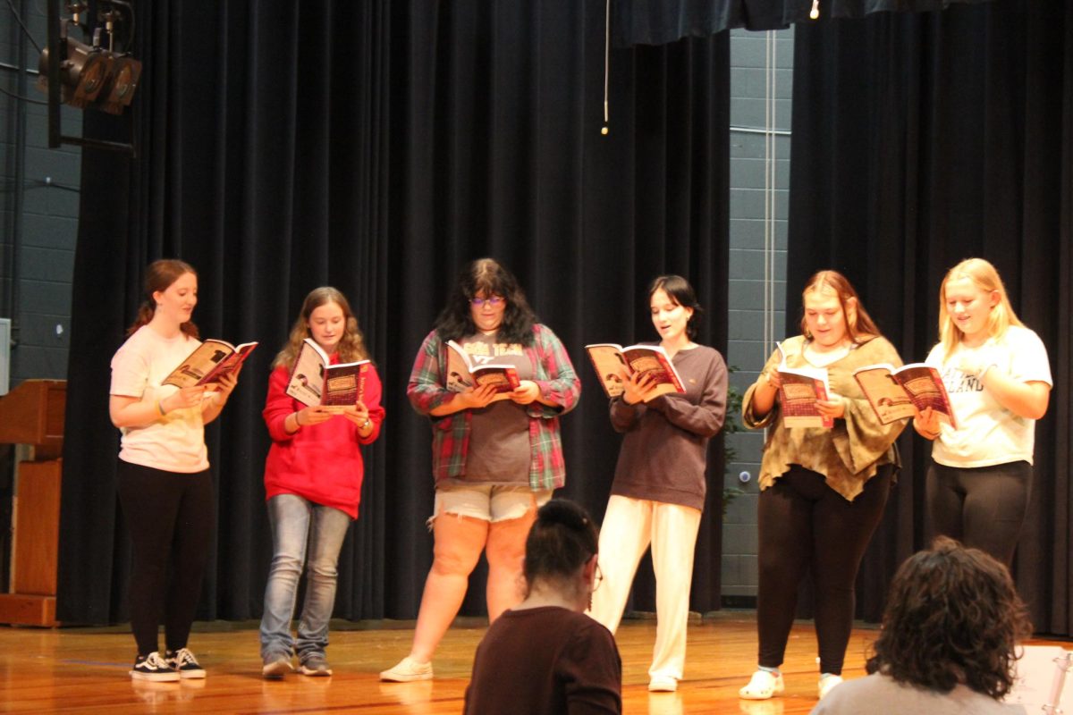 (from left to right) Sophomore Mary Jane Ingram, sophomore Ashley Kaufman, Senior Venus Slagle, sophomore Lily King, Sierra Hostetter, and freshman Abigail Woodford rehearse a scene.