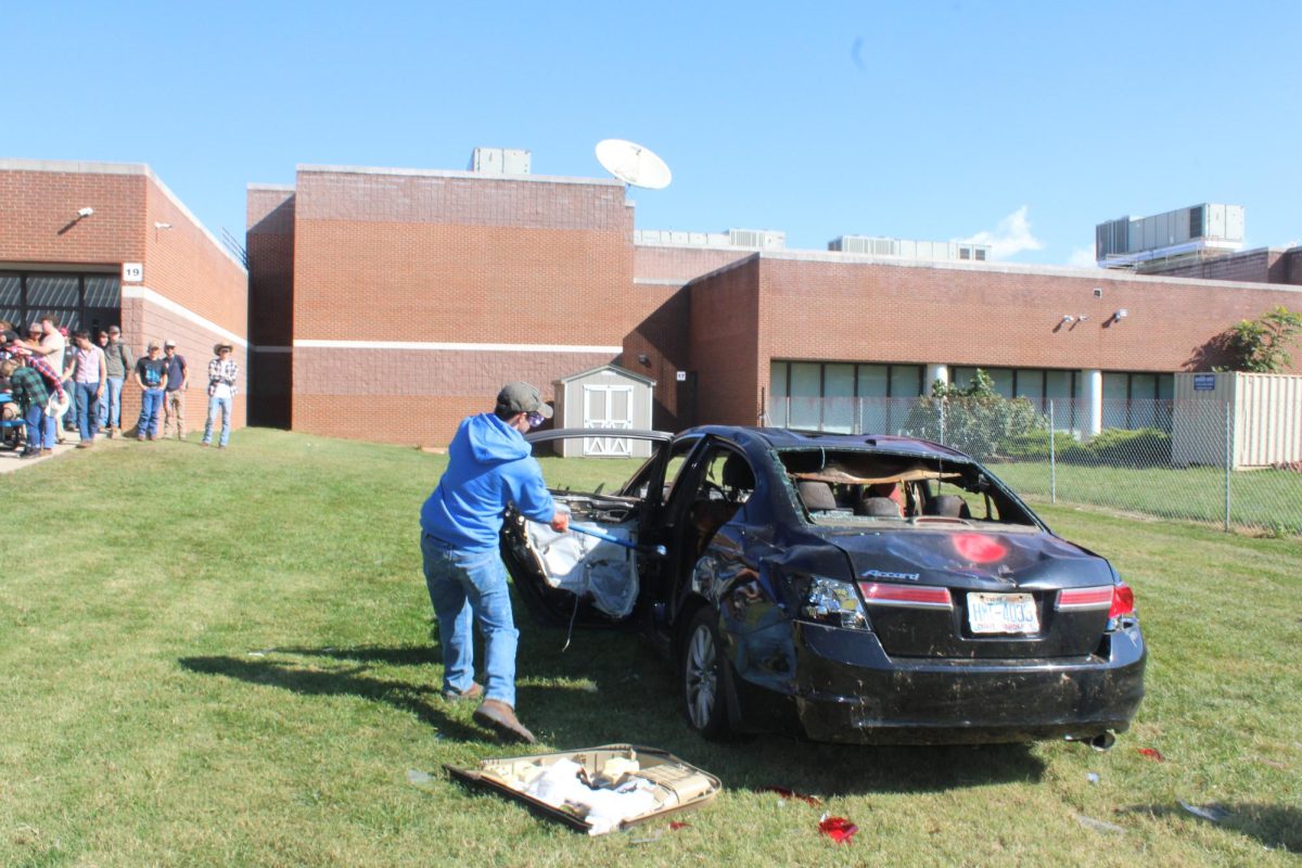 Senior Quentin Mohler hits the car with a sledgehammer.