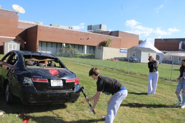 Sophomore Brody Price hits the car with a sledgehammer.