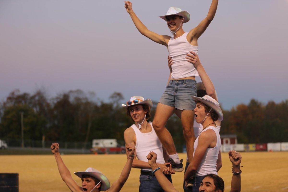 The cheerleaders successfully  perform a  trick. 