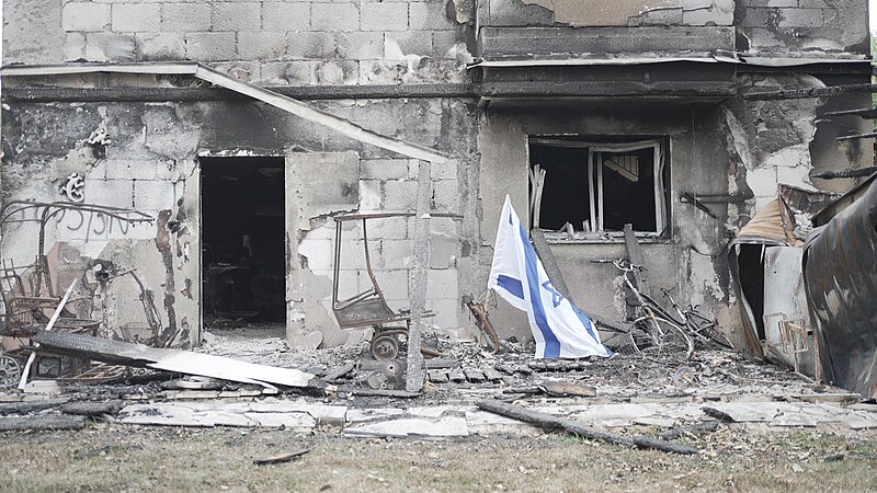 An Israeli flag in front of a bombed out building.