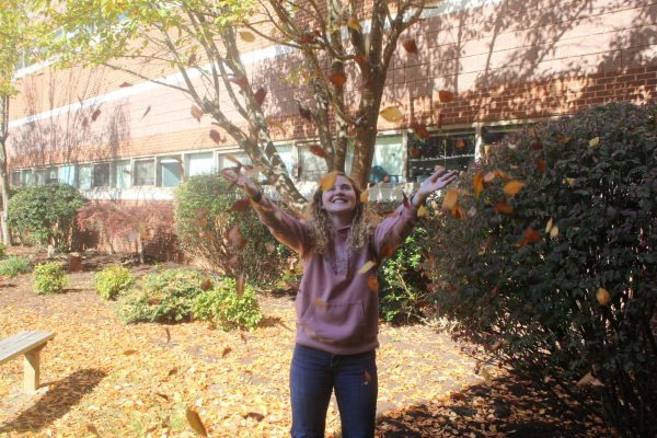 Junior Ella Cate Brown tosses leaves in the Courtyard.