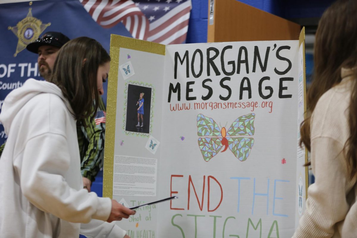 Club president Nadia Gaydos sets up poster at rock the ribbon for Morgans Message.
