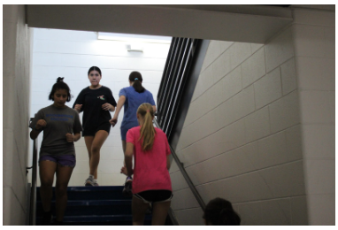  the girls soccer team running up and down the stairs to warm up.