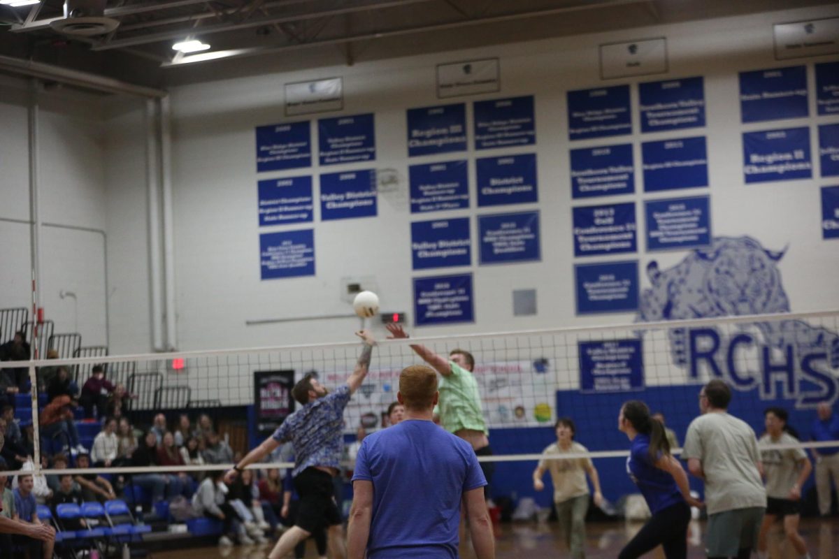 Chemistry teacher Zachery Rhodenizer attempts to block the ball from senior Gardner Clements.