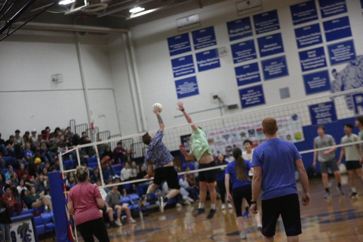 Chemistry teacher Zachery Rhodenizer attempts to block the ball from senior Gardner Clements.