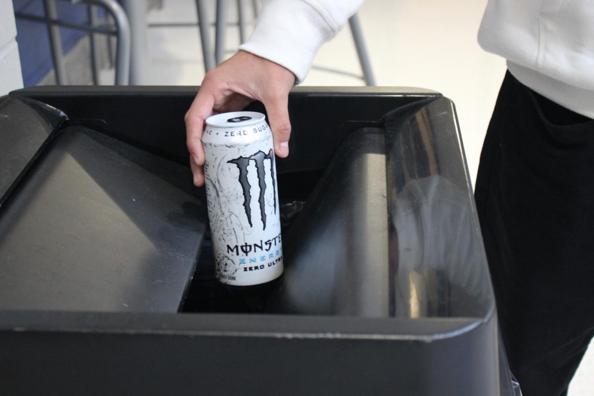 Student Jonathan Soriano throwing away a Monster Energy drink.