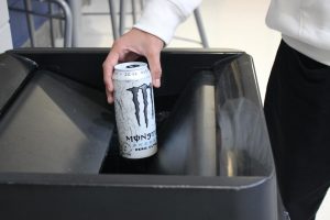 Student Jonathan Soriano throwing away a Monster Energy drink.