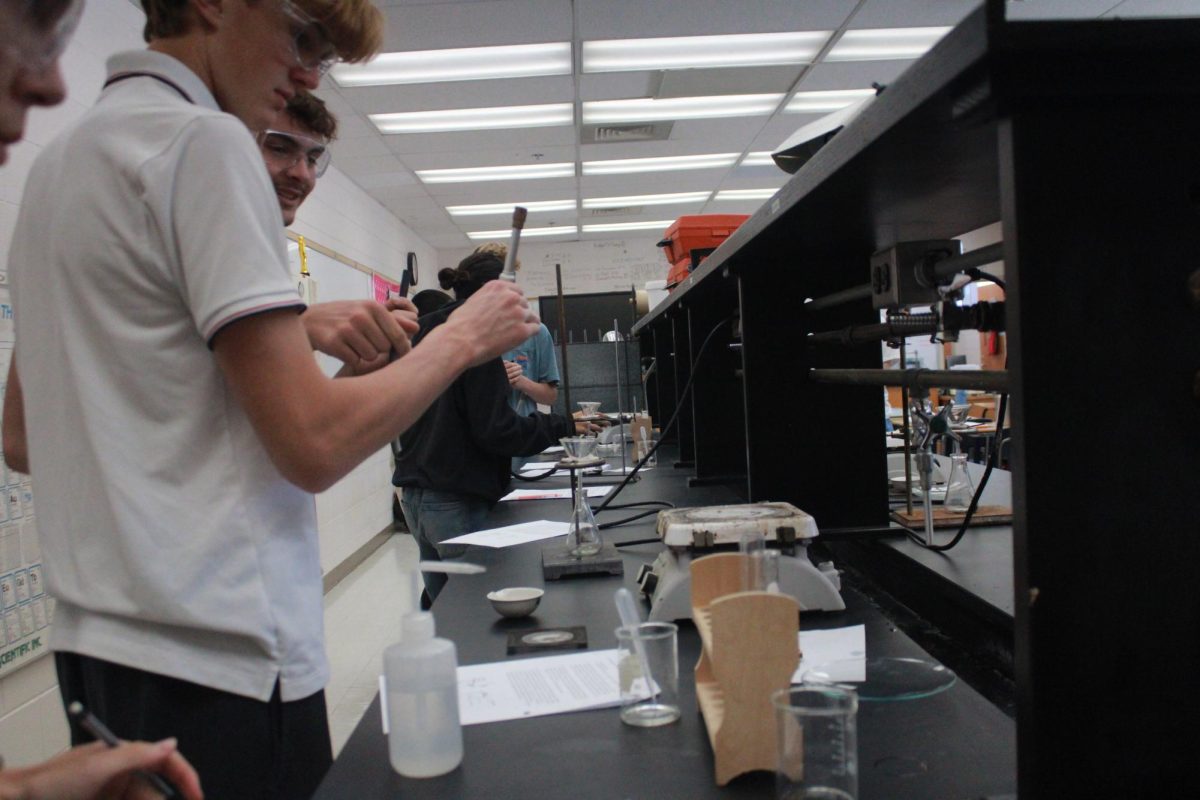 Students prepare Bunsen Burner for experiment.