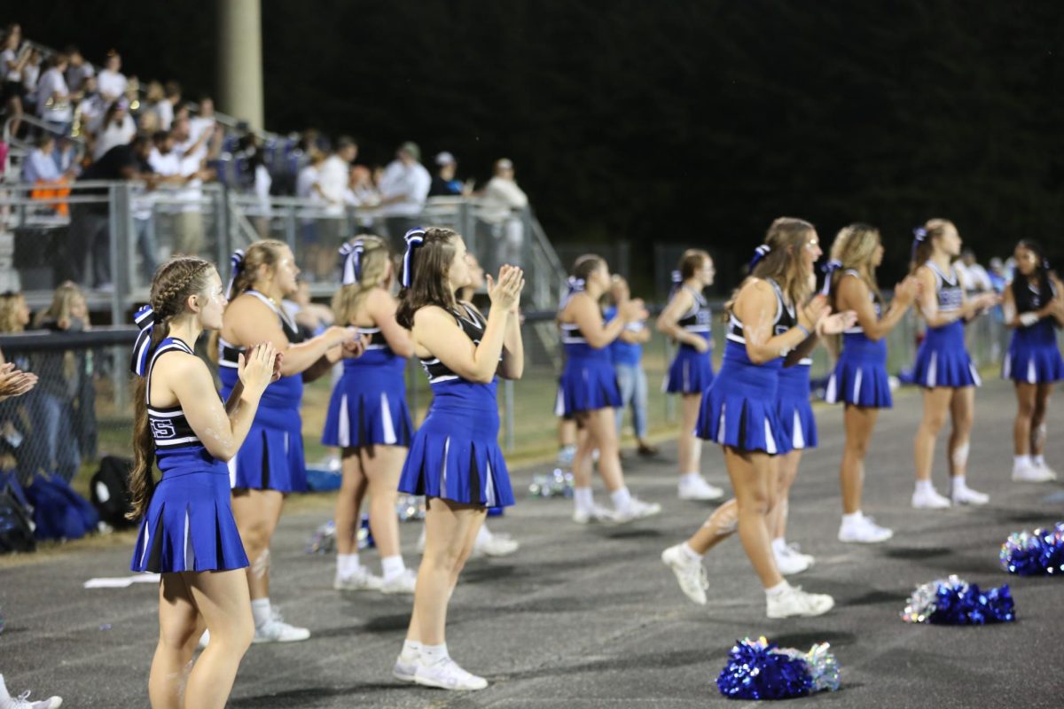Cheerleaders clap after a good football play.