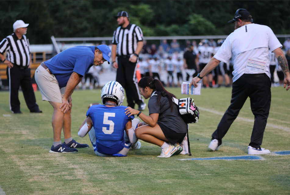Athletic trainer helps injured football player