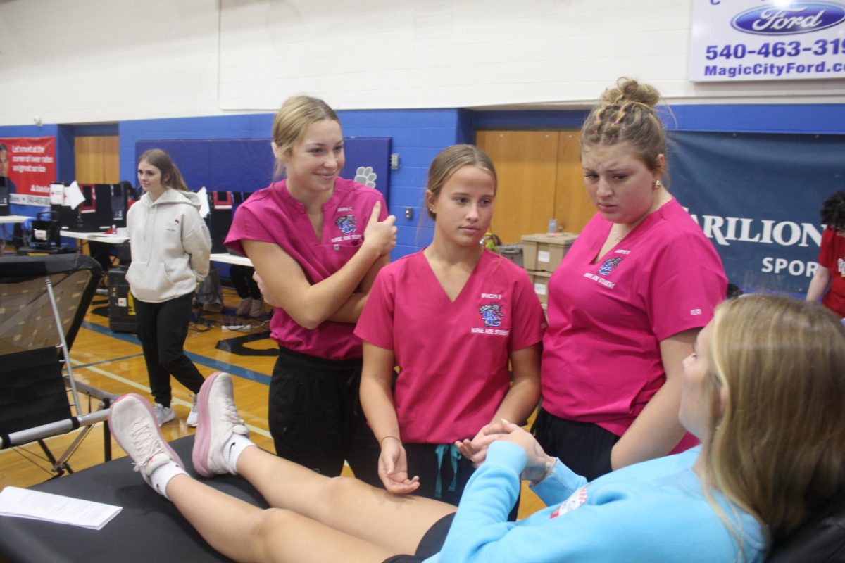 Juniors Maria Calomeris, Braelyn Polly, and Madeline White assist at the Blood Drive as nurse aide students.