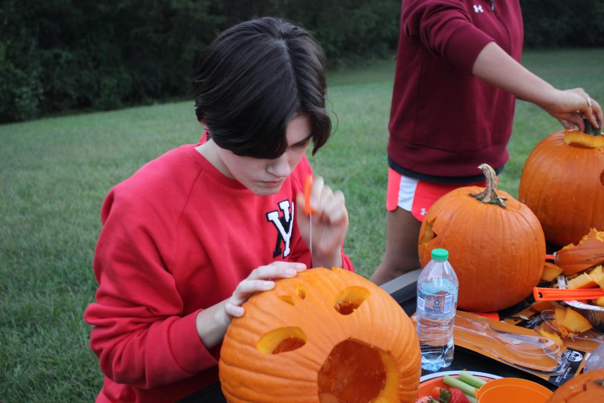 Senior Reece Havird finishes up carving their pumpkin.