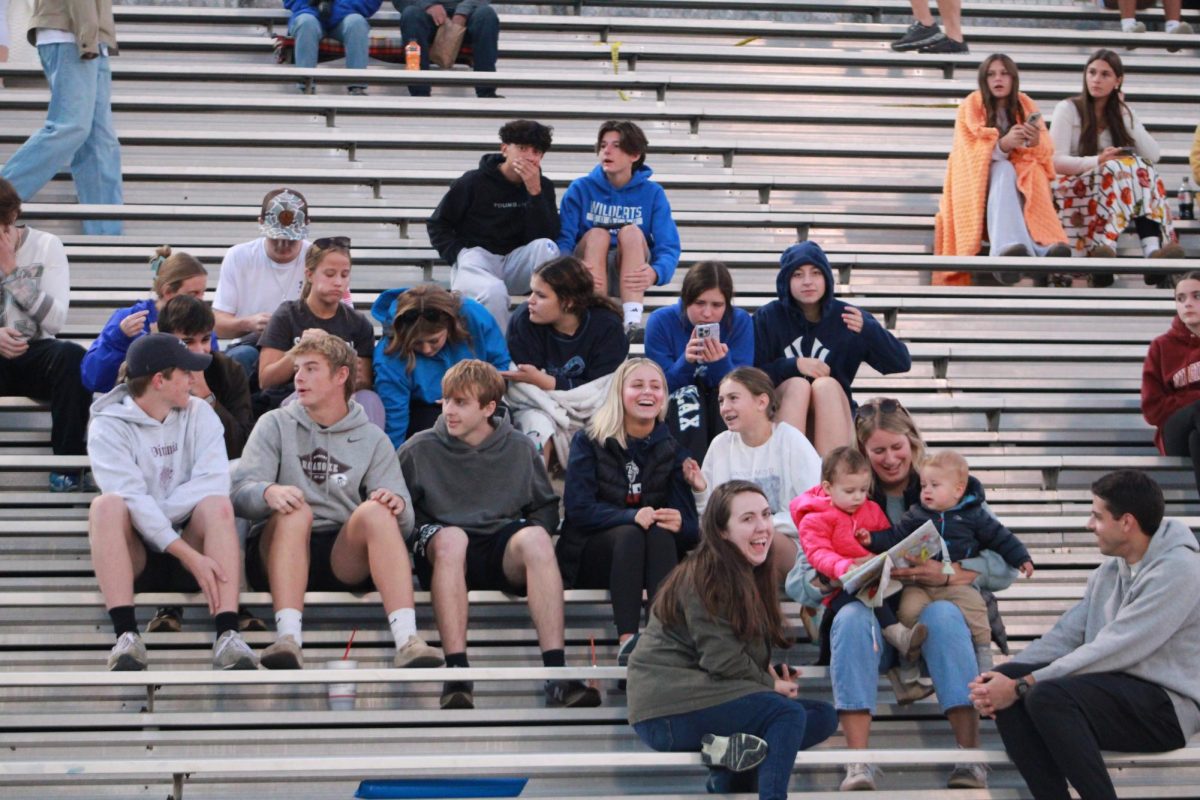 Student's in the fan section watch the game.