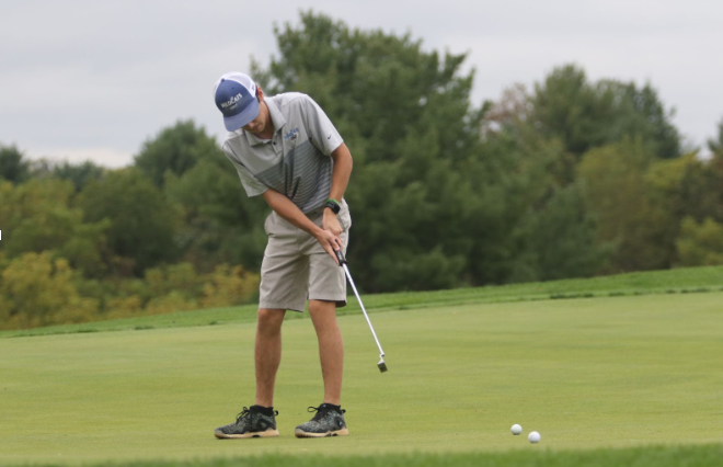 Senior Harrison Tanner putts the ball.