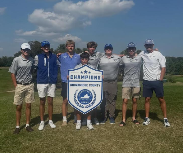 Golf team holds up championship sign