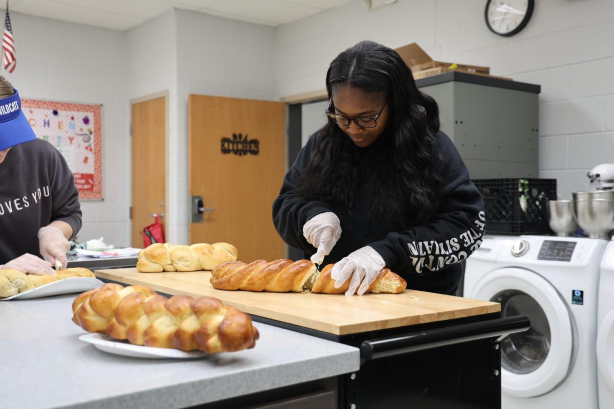 Junior Taliyah Richardson slices the freshly baked bread. Photo credits: Mary Holton